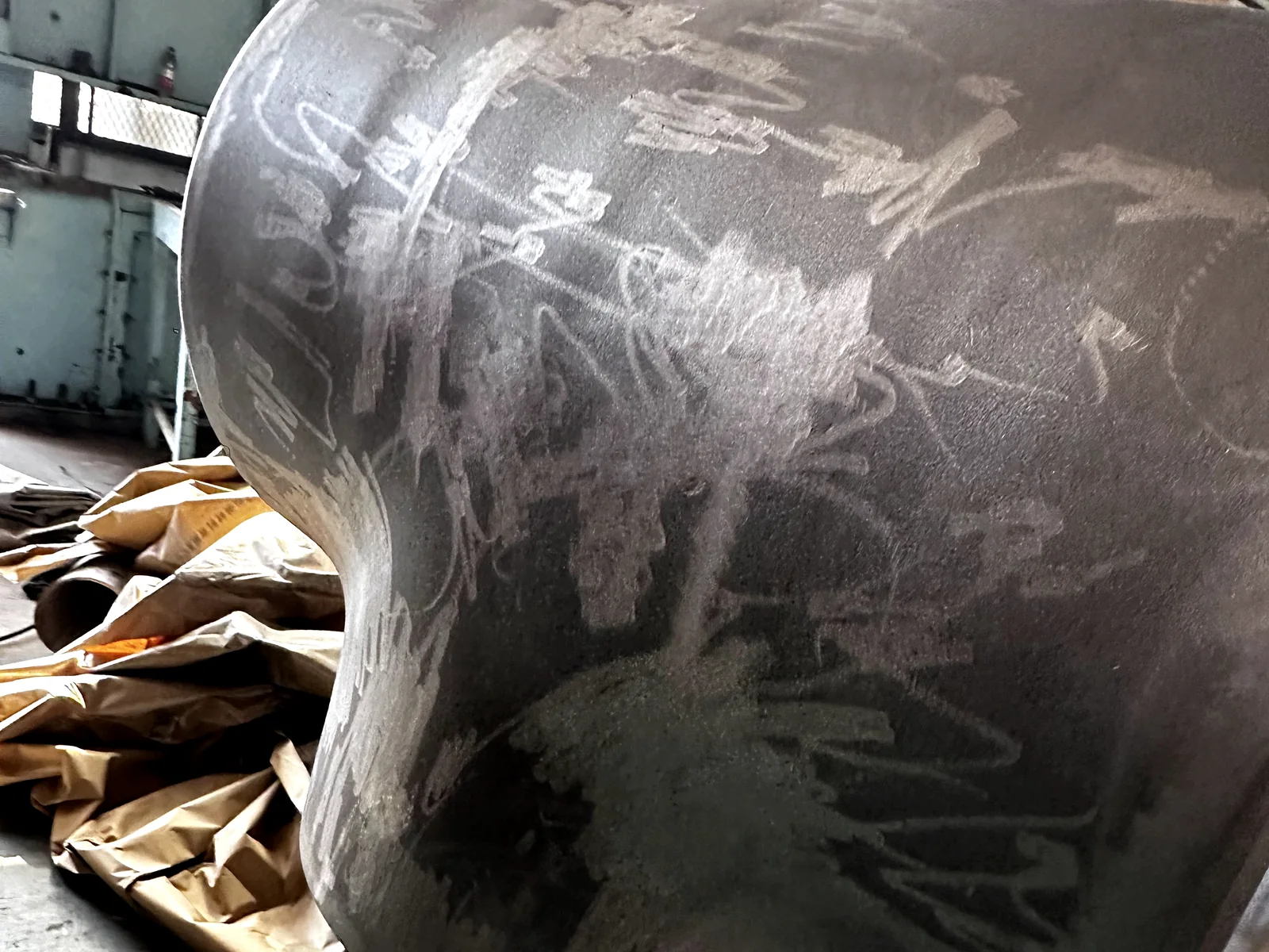 Close-up of a large formed stainless steel elbow before final finishing