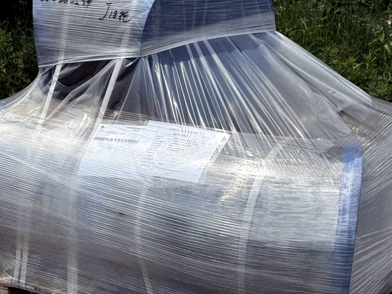 Large stainless steel elbow protected and secured on a pallet for delivery